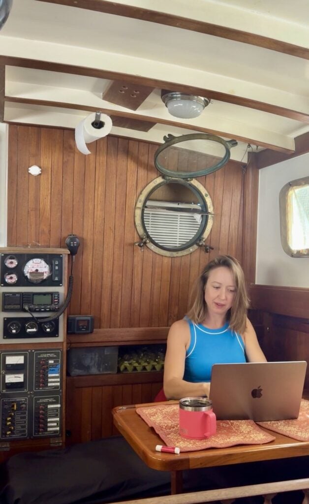 The nav station and cabin table aboard Kristin's sailboat, electronics panel on the bulkhead