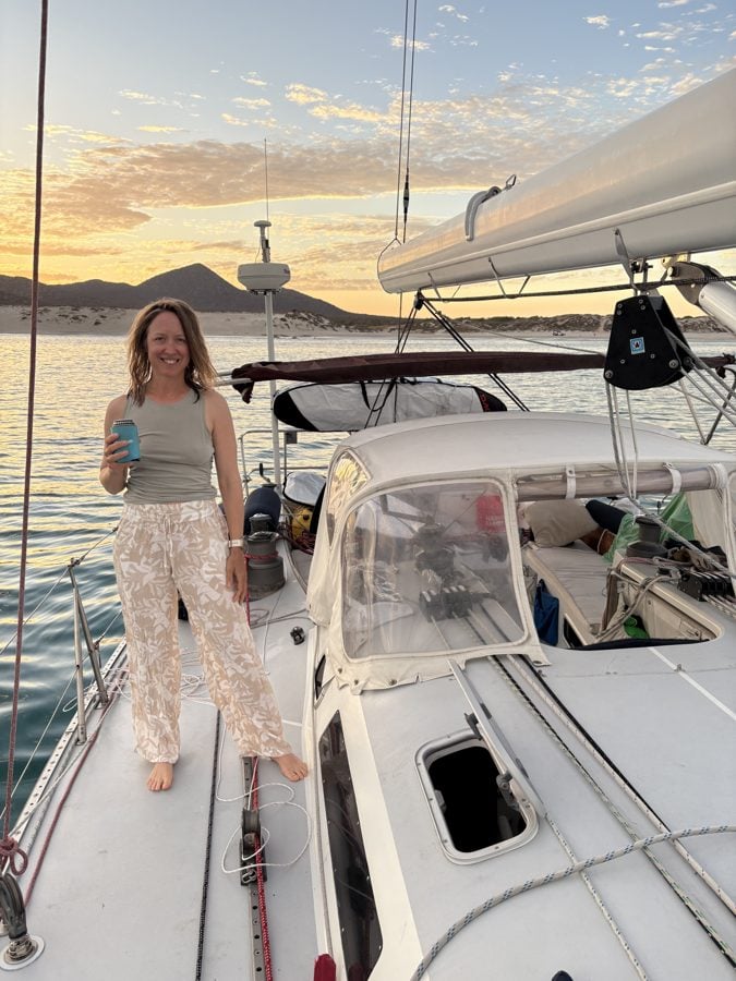 Kristin on the deck of her sailboat at golden hour