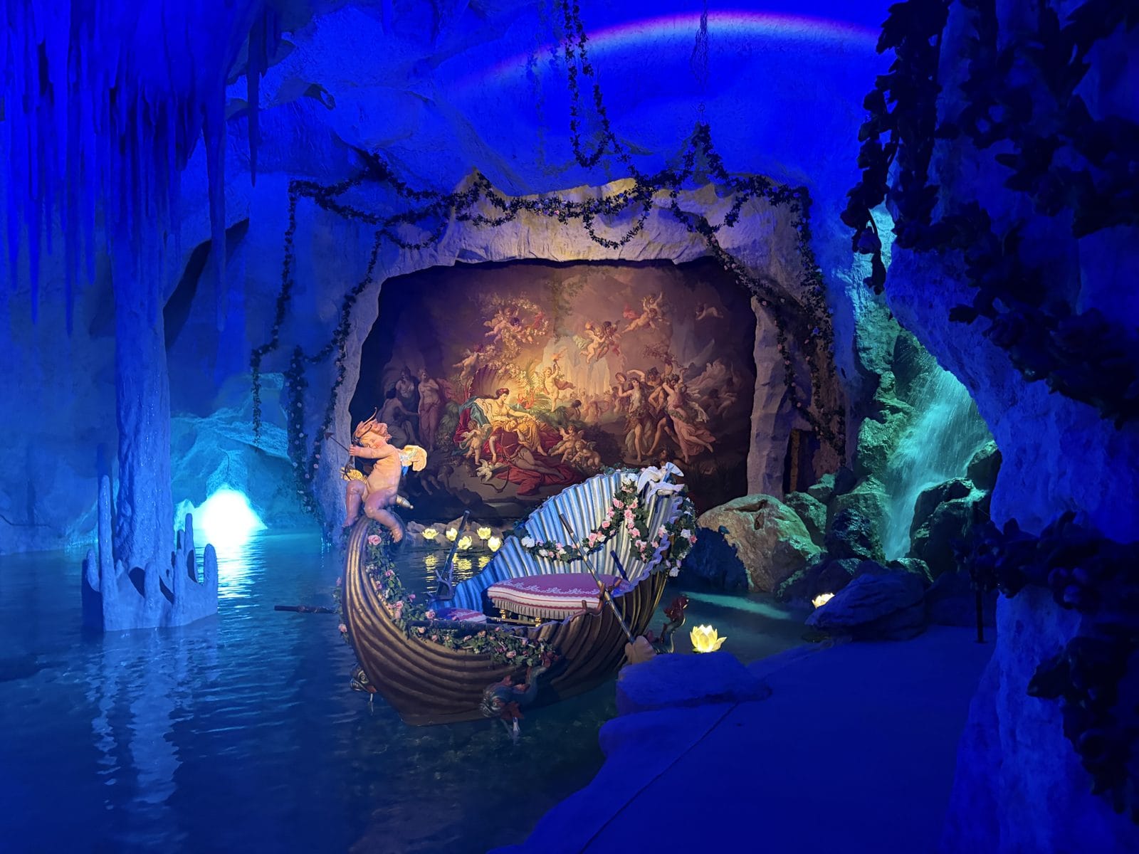 The Venus Grotto at Linderhof, an artificial cave lit blue with a painted stage and a gilded shell boat on the water